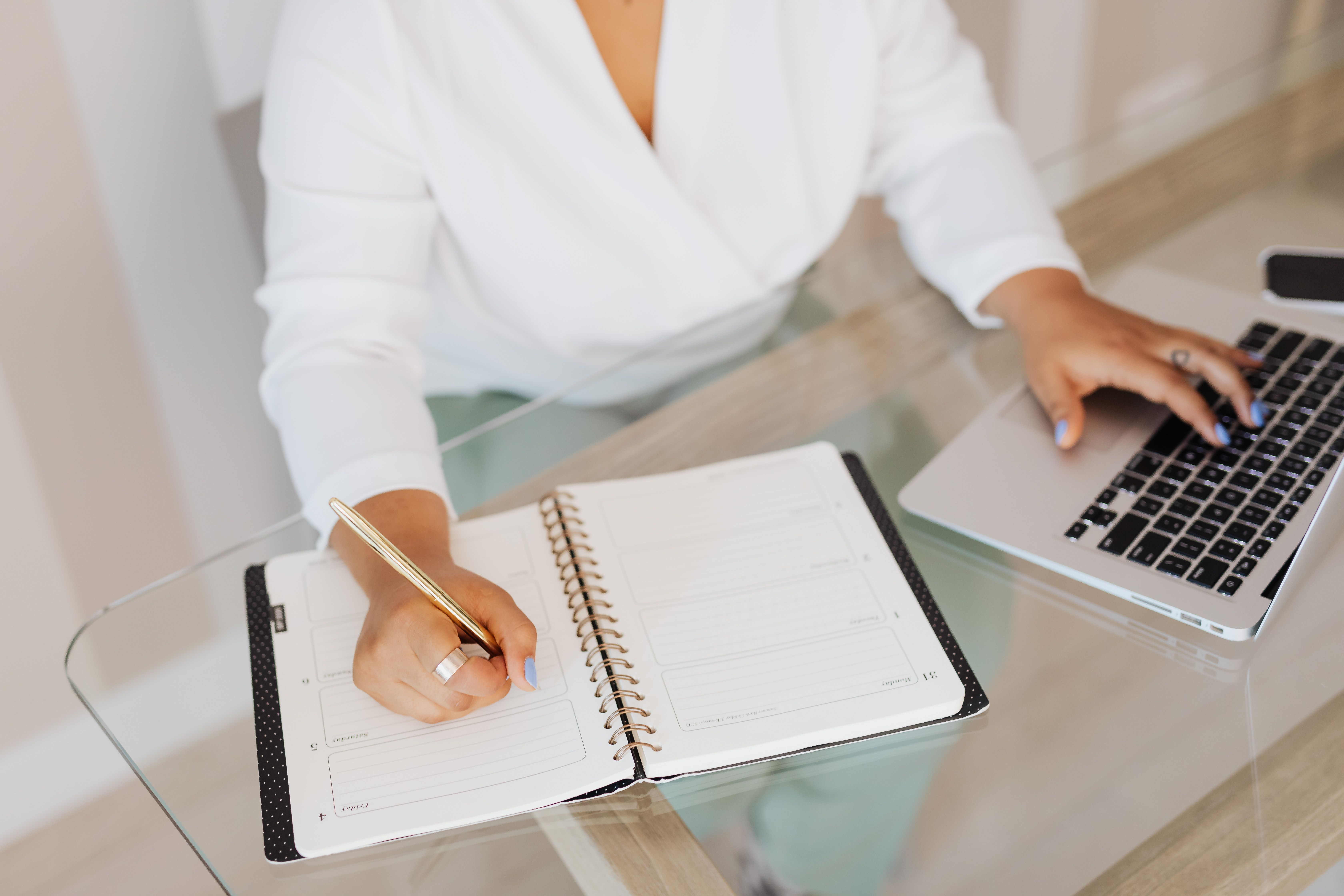 Entrepreneur planning work and typing on a laptop at a desk, representing AI-assisted business strategy.