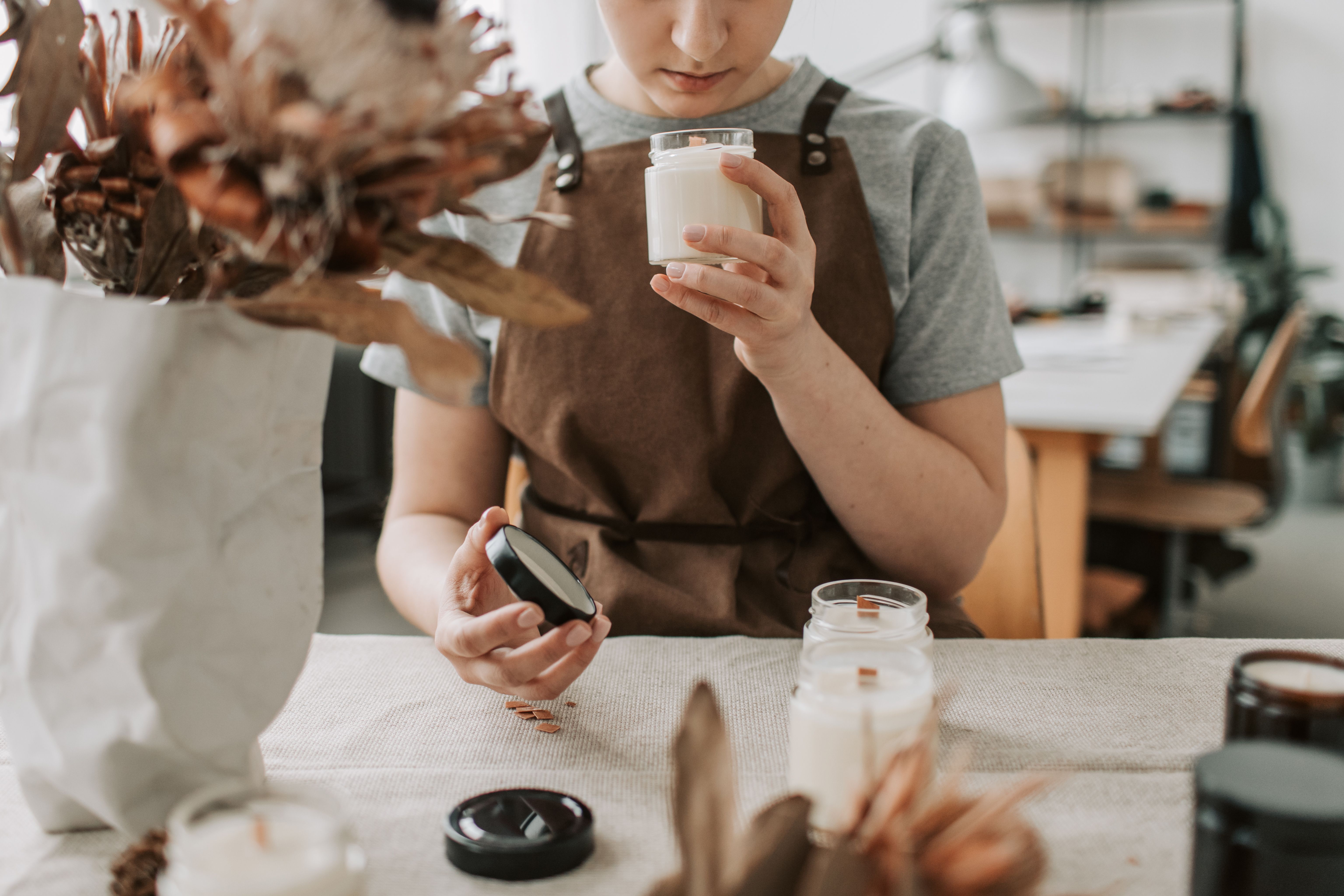 Woman making handmade candles in a small workshop for her creative product business.